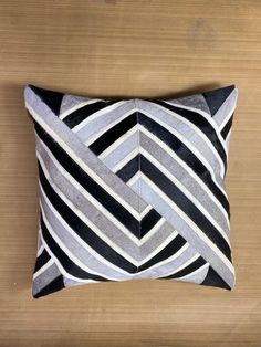 a black and white striped pillow sitting on top of a wooden floor