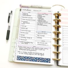 a planner and pen sitting on top of a white table next to an open notebook