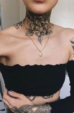 a woman with tattoos on her chest wearing a black top