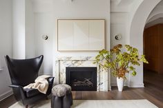 a living room filled with furniture and a fire place next to a painting on the wall