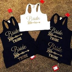 three bride tank tops on the floor with tags attached to them, one is white and two are black