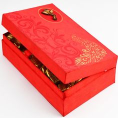 an open red box with gold designs on it