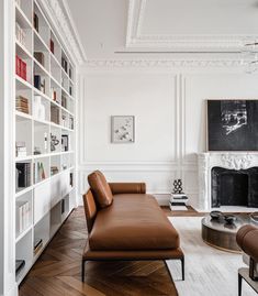 a living room filled with furniture and bookshelves next to a fire place in a fireplace