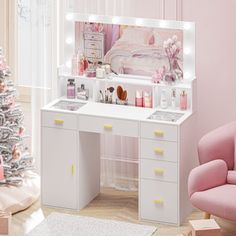 a white vanity with lights on it in a room next to a christmas tree and a pink chair