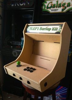 an old school arcade machine with buttons on the front and sides, sitting in a room