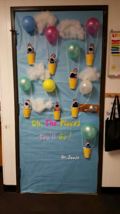 a classroom door decorated with balloons and people floating in the sky on ice cream cones