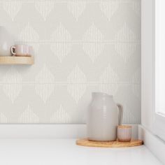 a shelf with two mugs on it next to a wallpapered wall in a kitchen