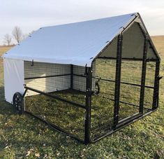 a black and white dog house with a cover on it's roof in the grass