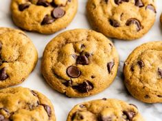 chocolate chip cookies are arranged on a marble counter top, ready to be eaten and served