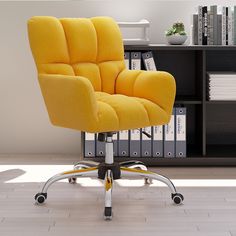 a yellow office chair sitting on top of a hard wood floor next to a book shelf