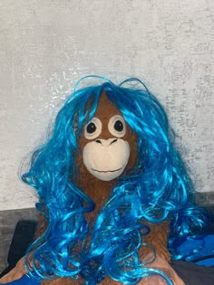 a stuffed animal with blue hair and big eyes