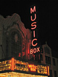 a large building with a sign that says music box on it's side at night