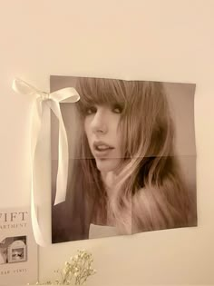 a white vase sitting next to a photo on a wall