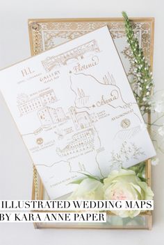 the illustrated wedding maps by kara anne paper are on display with flowers and greenery