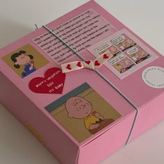 a pink box with some pictures on it and a heart hanging from the front side