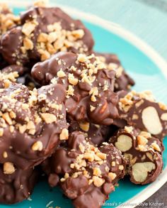 chocolate covered cookies on a blue plate with nuts in the middle and walnuts sprinkled on top