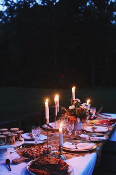 a dinner table with candles and food on it