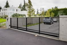 a car is parked in front of a house with a driveway and fenced area