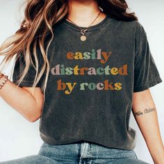 "Embrace your love for rocks with our 'Easily Distracted by Rocks' T-shirt. Perfect for nature enthusiasts and geology lovers. Whether you're a budding geologist or just love collecting rocks, this shirt is sure to get a laugh. And if you're looking for the perfect gift for the rockhound in your life, this rock lover tshirt is the real deal! Grab yours today & get ready to rock the world!                                 ＊𝗡𝗢𝗧 𝗔𝗩𝗔𝗜𝗟𝗔𝗕𝗟𝗘 𝗜𝗡 𝗦𝗧𝗢𝗥𝗘𝗦＊ 👚 GET TO KNOW YOUR EASILY DISTRACTED BY ROCKS T-SHIRT This Easily Distracted By Rocks T-shirt is printed on a Comfort Colors® 1717 Unisex Garment-Dyed Heavyweight T-Shirt with ink using a direct-to-garment printer by our production partner. They will print your item and send it right to your door! ✽ 100% Ring-Spun Cotton ✽ Medi Geology Shirt, Collecting Rocks, Geology Humor, Rock Hunting, Tshirt Ideas, Easily Distracted, Rock T Shirts, Hunting Shirts, Rock Shirts