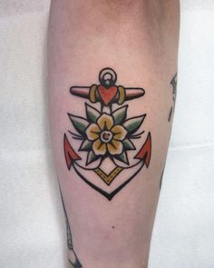 an anchor and flower tattoo on the leg