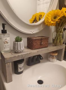 a bathroom sink with sunflowers and soap