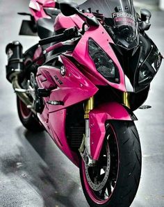 a pink and black motorcycle parked in a garage