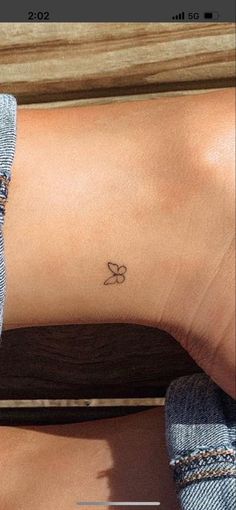 a woman's foot with a small butterfly tattoo on her left ankle and right leg