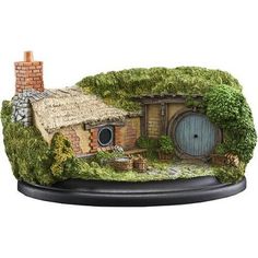 an image of a miniature garden house with grass growing on it's roof and door