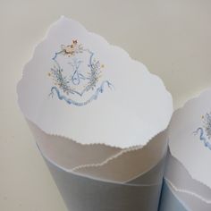 three white paper cups with blue designs on them