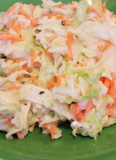 a green plate topped with coleslaw and carrots