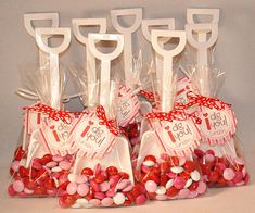 there are many candy bags in the shape of shovels with tags on them that say it's 1st birthday