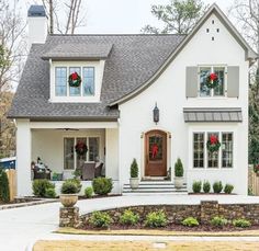 a white house with wreaths on the front door