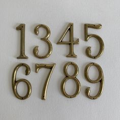 brass numbers and numerals are displayed on a white surface