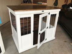 a dog kennel in the garage with its doors open