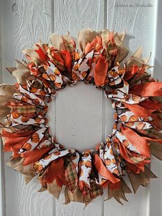 a wreath made out of burlocks and oranges on a white wooden door