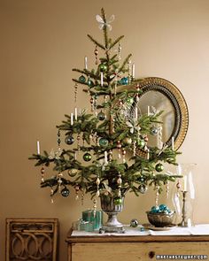 a small christmas tree sitting on top of a table next to a mirror and dresser