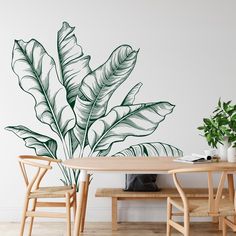 a dining room table and chairs with a large wall decal on the wall behind it