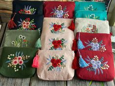 six embroidered bags with flowers and tassels on them