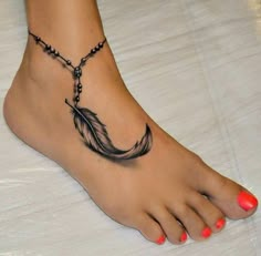 a woman's foot with a black and white feather tattoo on the bottom of it