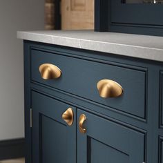 a blue cabinet with brass handles and knobs on the doors is shown in this image