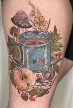 a cup of coffee on the thigh with flowers and leaves around it, surrounded by mushrooms