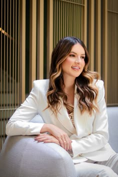 a woman sitting on top of a gray couch