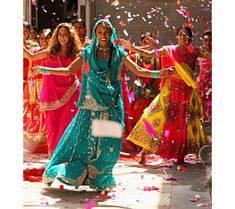 a group of women in colorful dresses are throwing confetti