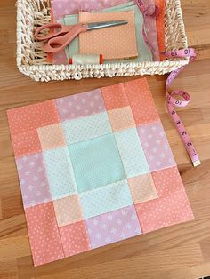 a basket with scissors, tape and fabric next to some crafting supplies on a wooden floor