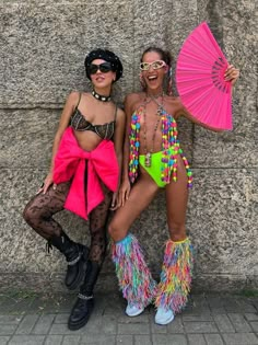 two women dressed in colorful clothing posing for the camera