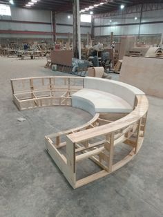 a circular bench made out of plywood in a warehouse