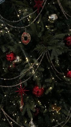 the christmas tree is decorated with red and gold ornaments