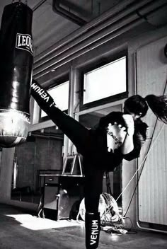 a man in black shirt kicking a punching bag