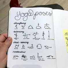 a person holding a notebook with yoga poses written on it