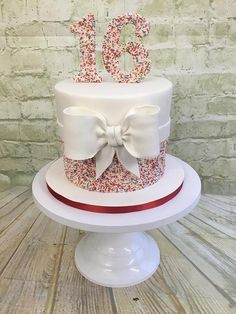 a birthday cake decorated with sprinkles and a bow